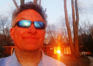 Lake Winneconne house and sunset reflected in his sunglasses